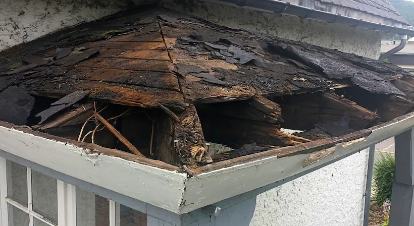 Rehabilitación de fachadas en Granada: alero de madera deteriorado antes de la reparación